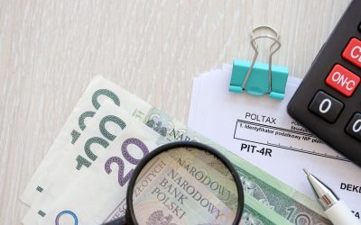 Annual declaration of income tax advances, PIT-4R form on accountant table with pen and polish zloty money bills close up