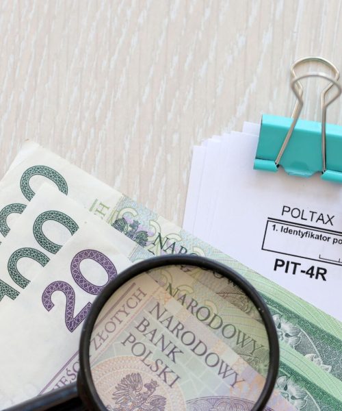 Annual declaration of income tax advances, PIT-4R form on accountant table with pen and polish zloty money bills close up