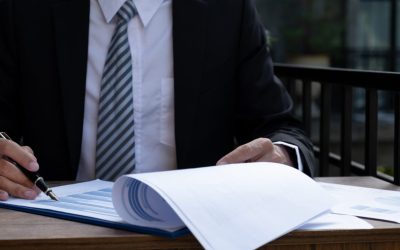 Businessmen bookkeeper hand holding pen and use calculator, laptop analysis the graph for Setting challenging business goals and ready to achieve target at home office.