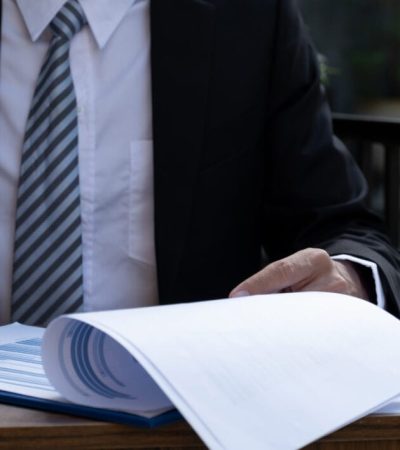 Businessmen bookkeeper hand holding pen and use calculator, laptop analysis the graph for Setting challenging business goals and ready to achieve target at home office.