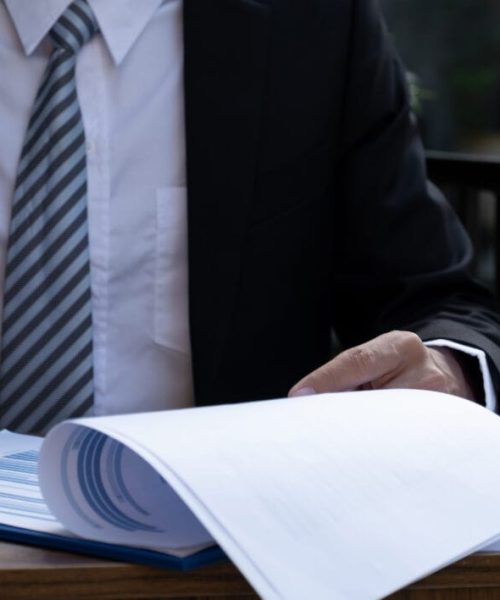 Businessmen bookkeeper hand holding pen and use calculator, laptop analysis the graph for Setting challenging business goals and ready to achieve target at home office.