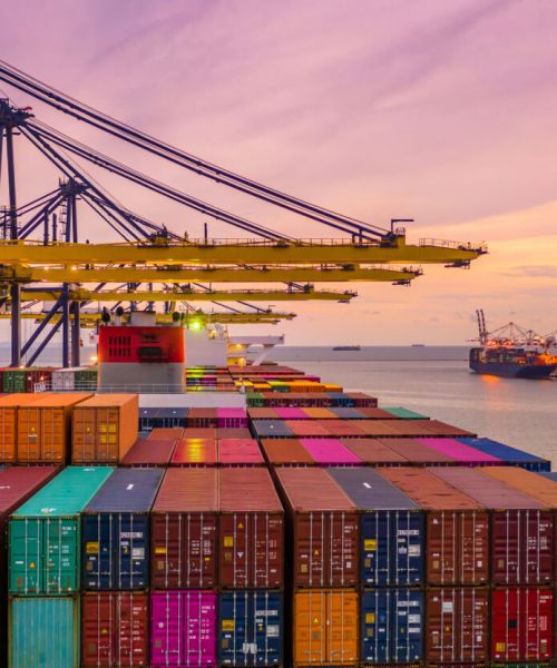 Container ship loading and unloading in deep sea port at sunset, Aerial view of business logistic import and  export freight  transportation by container ship in open sea.