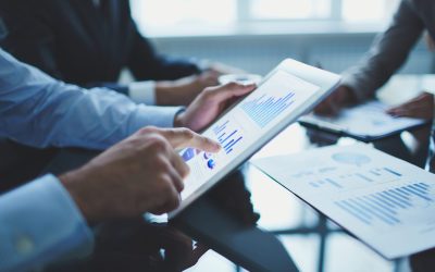 Analyzing electronic document Image of businessperson pointing at document in touchpad at meeting