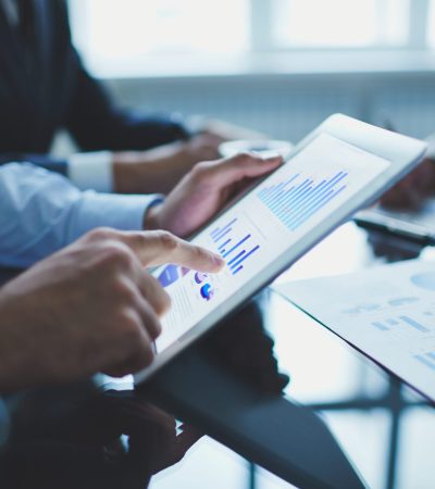Image of businessperson pointing at document in touchpad at meeting