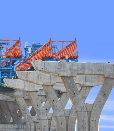 Launching gantry Structure for installing concrete Segment Joint on foundation of Flyover Expressway in road Construction site against blue sky background