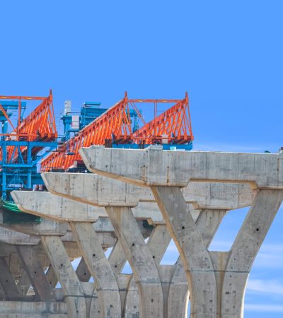 Launching gantry Structure for installing concrete Segment Joint on foundation of Flyover Expressway in road Construction site against blue sky background