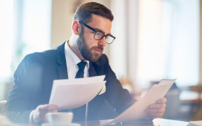 Looking Through Papers 2025 03 15 02 01 36 Utc Confident banker reading financial papers while sitting in cafe