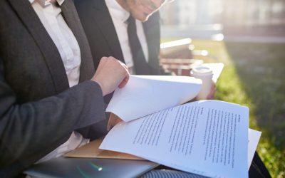 Business papers or contracts held by businesswoman during discussion with colleague at meeting