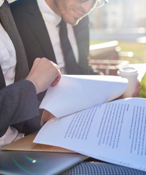 Business papers or contracts held by businesswoman during discussion with colleague at meeting