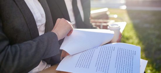 Business papers or contracts held by businesswoman during discussion with colleague at meeting