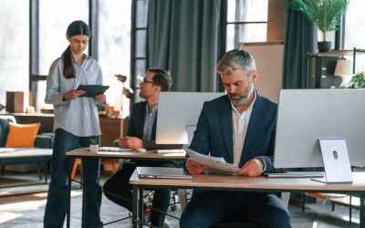 Three people are busy in the office. Group of employees are working together.