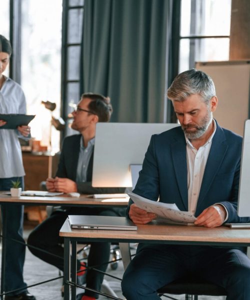 Three people are busy in the office. Group of employees are working together.