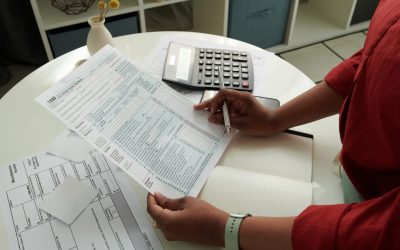 Close-up of African girl checking and calculating her domestic bills at table using calculator